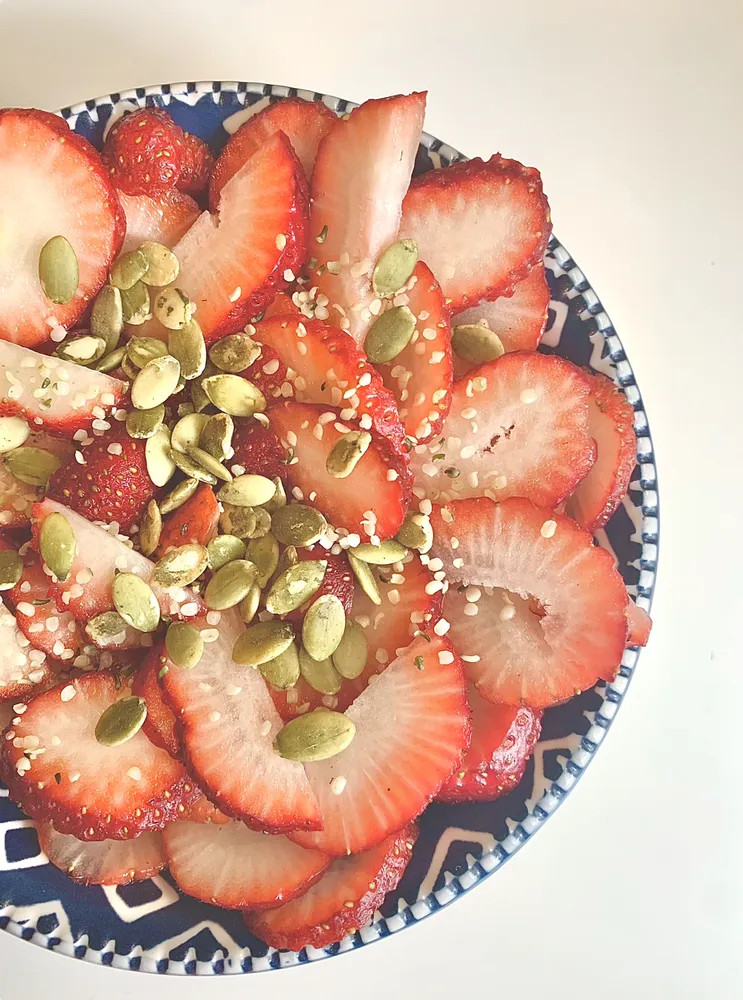 sliced strawberries with pepitas and sesame